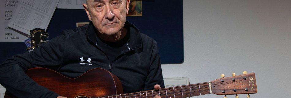Guitarist in studio with acoustic guitar